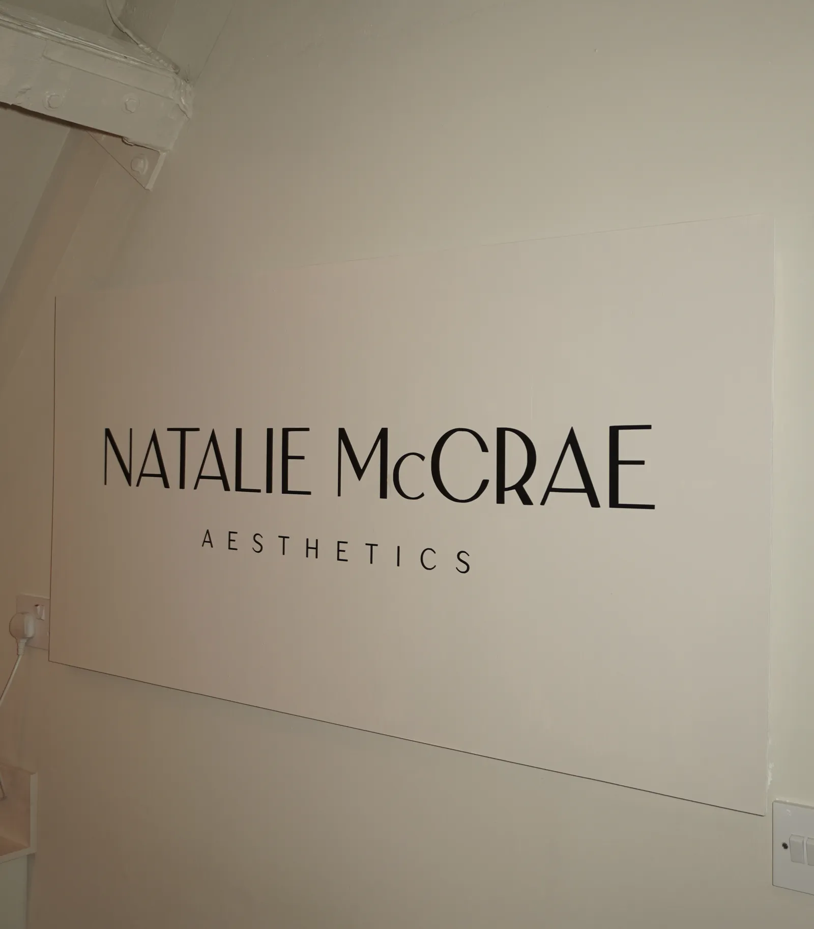 The Natalie McCrae Aesthetics sign on the clinic wall
